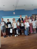 Grupa laureatów konkursu z nagrodami oraz pamiątkowymi dyplomami.
