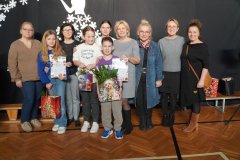 Na granatowym tle z zimową dekoracja znajdują się: Panie Dyrektor: Marlena Błachowicz, Monika Przemyłska, przedstawiciele trzech zwycięskich klas (z dyplomami w rękach) wraz ze swoimi wychowawczyniami oraz opiekunowie Samorządu Uczniowskiego: Aneta Szatkowska i Celina Krysińska