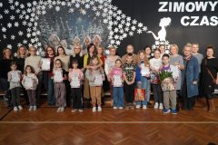 Na granatowym tle z zimową dekoracja znajdują się: Panie Dyrektor: Marlena Błachowicz, Monika Przemyłska, przedstawiciele klas biorących udział w konkursie "Przyjazna Klasa" (z dyplomami w rękach) wraz ze swoimi wychowawczyniami oraz opiekunowie Samorządu Uczniowskiego: Aneta Szatkowska i Celina Krysińska
