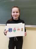 Uczennica Maria Bryk pozuje ze swoją  pracą, która zajęła drugie miejsce w szkolnym konkursie na najlepszy rebus.