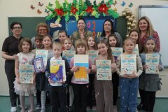 Zdjęcie przedstawia wszystkich Uczestników  konkursu, Członków jury oraz Organizatorów. Osoby te pozują do zdjęcia na tle okolicznościowej dekoracji