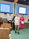 Na tle wyświetlonego slajdu ,,Słowa mają wielką moc’’ stoi nagrodzony uczeń oraz organizatorzy konkursu.
