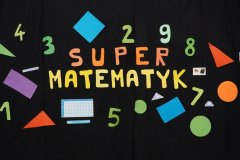 Na czarnym tle umieszczony jest napis Super Matematyk. Dookoła liter znajdują się symbole matematyczne: liczby, zdjęcia figur geometrycznych oraz przyborów do mierzenia długości.