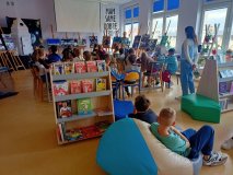 grupa uczniów w czytelni biblioteki szkolnej słucha prelekcji o kosmicznych odkrywcach