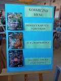 plakat z saszetkami liofilizowanego kosmicznego menu: pierogi z kapustą i grzybami, zupa pomidorowa, pieczone jabłka z kruszonką