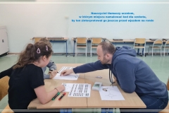 Nauczyciel tłumaczy uczniom szyfrowanie kodów dla ozobota.