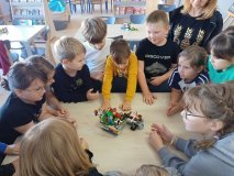 grupa uczniów stoi przy stole i opowiada całej klasie o swoim projekt zbudowanym z klocków LEGO