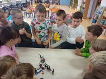 uczniowie w skupieniu słuchają kolegów, którzy prezentują swój projekt z klocków LEGO