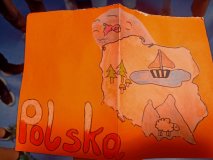 List – na pomarańczowym tle narysowane kontury Polski i rysunek - na północy - wody i ryby, w środkowej części - jeziora i żaglówki, na południu - gór i owcy, podpis „Polska”.