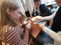 Drużyna z SP 22 rozwiązuje jedno z zadań konkursowym, dziewczynka robi łańcuszek na szydełku.