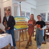 Drużyna z SP 22 pozuje do zdjęcia w Sali Kolumnowej Książnicy Płockiej. Dziewczyny w rękach trzymają książki – literackie menu konkursu, chłopiec miniaturę płockiego pomnika Marceliny Rościszewskiej.