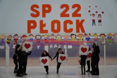 Prezentacja układu tanecznego na forum szkoły. Tancerki, w swojej choreografii, wykorzystują plansze prezentujące rożne rodzaje niepełnosprawności.