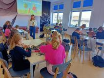 Zajęcia „LEGO w bibliotece” – uczniowie z klasy 4b w grupach siedzą przy stołach i budują z klocków LEGO Akademię Pana Kleksa.