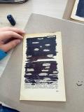 Zajęcia „Blackout poetry” - fotografia leżącej na stole zadrukowanej kartki ze starej książki z zakreśloną czarnym markerem częścią tekstu.