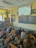 Pracownia – sala lekcyjna, uczniowie z klasy 3. siedzą na podłodze i oglądają prezentację „Bookcrossing w Polsce”.