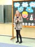 Na tle dekoracji dziewczynka recytuje przygotowany przez siebie utwór literacki.