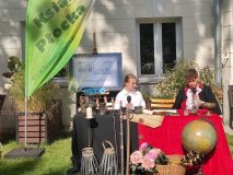 Dwoje uczniów w strojach z epoki siedzi za stołem i czyta fragmenty dramatu „Kordian” Juliusza Słowackiego podczas akcji Narodowego Czytania w ogrodzie Książnicy Płockiej.