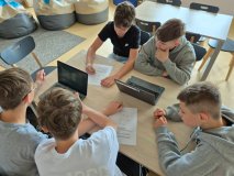 Praca z komputerami uczniów klasy 8b podczas wyszukiwania informacji do wypełnienia krzyżówki.
