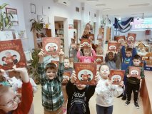 Pierwszoklasiści w uniesionych do góry dłoniach prezentują książkę „Wnuczka antykwariusza”, którą otrzymali jako prezent w ramach wyprawki czytelniczej w akcji społecznej „Mała książka – wielki człowiek”.