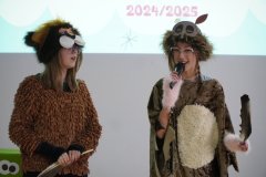 Dwie uczennice z klasy siódmej w brązowym przebraniu występują na uroczystości jako potwory książkowe -  Pożeracze Książek.