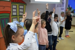 Grupa uczniów klas pierwszych składa przyrzeczenie, prawe dłonie uniesione do góry