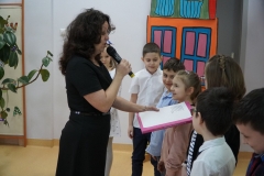 Dyrektor Agnieszka Gawlińska wielką księgą z bajkami dokonuje pasowania na czytelników