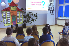 Grupa uczniów ogląda film animowany „Dlaczego warto czytać książki”