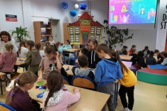 Pierwszaki układają z plastikowych korków od butelek pierwszą literę swojego imienia – widok na całą grupę