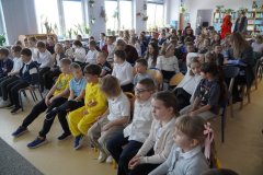 Uczniowie klas pierwszych w oczekiwaniu na uroczystość pasowania na czytelnika w bibliotece szkolnej. 