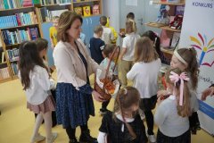 Pani Renata Piliczewska, nauczycielka biblioteki, częstuje uczniów cukierkami na zakończenie pasowania na czytelnika. 