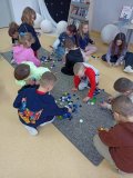 Pierwszaki układające pierwszą literę swojego imienia z nakrętek plastikowych. 