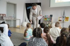 Uczennica odpowiadająca do mikrofonu na zagadki związane z biblioteką i bajkami. 