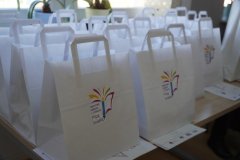 blat stołu, na którym ustawiono torby z logo konkursu, a w nich nagrody dla wyróżnionych i nagrodzonych
