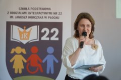 zbliżenie na postać kobiety – bibliotekarki, która w imieniu gospodarzy wita gości