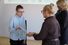 Dyrektor Szkoły Podstawowej nr 22 i przewodnicząca jury wręczają chłopcu dyplom 