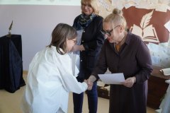 Dyrektor Szkoły Podstawowej nr 22 i przewodnicząca jury wręczają dziewczynce dyplom i torbę z logo konkursu