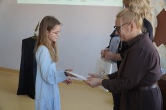 Dyrektor Szkoły Podstawowej nr 22 i przewodnicząca jury wręczają dziewczynce dyplom i torbę z logo konkursu