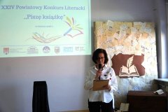 Zastępca Dyrektora Książnicy Płockiej – kobieta – czyta wybrany fragment nagrodzonej pracy konkursowej