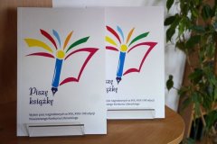 zdjęcie z publikacją, która zawiera fragmenty nagrodzonych archiwalnych prac, na okładce logo konkursu – kolorowe pióro