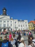 Grupa uczniów znajdujących się przed Ratuszem i przygotowujących się do kolorowego korowodu.