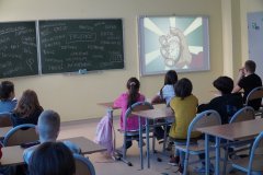 Sala lekcyjna. Uczniowie klasy czwartej siedząc w ławkach, oglądają film zaczerpnięty z kampanii „Bądź kumplem – nie dokuczaj” firmowanej przez Cartoon Network.pl
