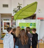 Dzieci oglądają plakat o recyklingu.