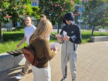 Uczniowie klasy 7e na happeningu wręczają ulotki przechodniom.