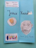 niebieski złożony lapbook, na nim portret Korczaka oraz pokolorowane kredkami rysunki, m.in. Korczak maszerujący z gromadką dzieci