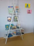 czytelnia biblioteki szkolnej - na białym stojaku prezentowane są książki o Marii Skłodowskiej-Curie