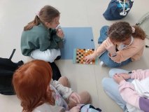 Grupa uczennic grających w planszowe warcaby.