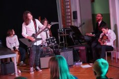 Grupa uczniów grająca na instrumentach: gitarze, perkusji.