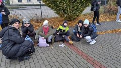Grupa uczniów oczekująca, wraz z nauczycielem, na starcie rajdu.
