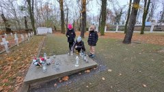 Dzieci zapalające znicze na grobie poległych obrońców Płocka z 1920 roku.