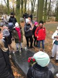 Uczestnicy rajdu słuchający opowieści i ciekawostek związanych z historią żołnierskiej nekropolii